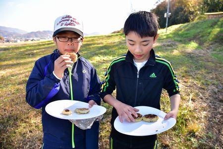 出来上がったクッキーを食べている男の子2名の写真