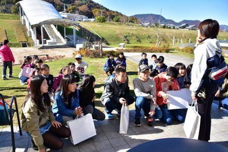 公園の広場に集合して指導者の方の話を聞いている子供たちの写真