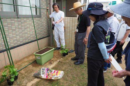 講師の藤堂さんが参加者達にプランターを手で指しながら説明をしている写真