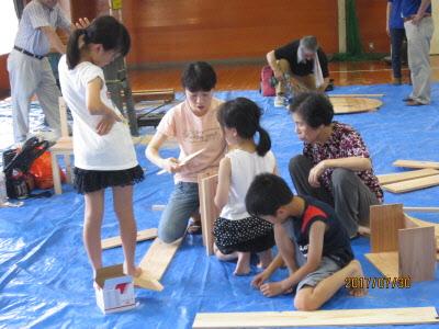 お母さんと、おばあちゃんと3人の子供たちが一緒に制作をしている写真