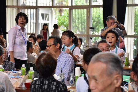 高齢者の肩たたきをしている小学生の写真