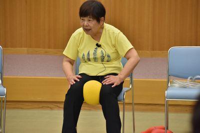 講師の清水 ヒロミさんが椅子に座り太ももでボールを挟んでいる写真