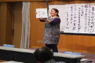 大浦 美樹先生が紙に書かれた漢字を参加者たちに見せてクイズを出している写真