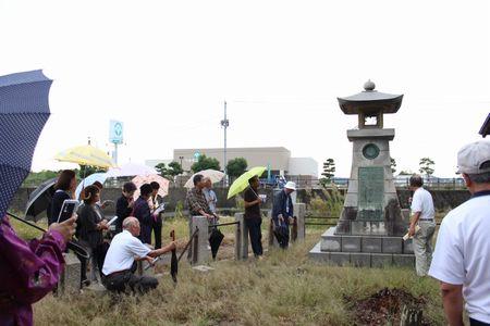 ラジオ塔の前で説明をしている男性の話を近くで聞いている参加者の人達の写真