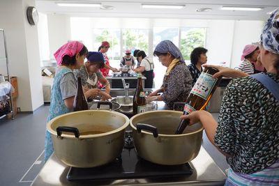 鍋に仁尾酢を注ぎ込んでいる女性の写真