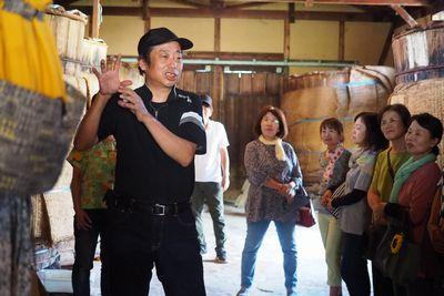 全身黒の服装で統一した中橋 康一さんが樽の前で参加者たちに話をしている写真