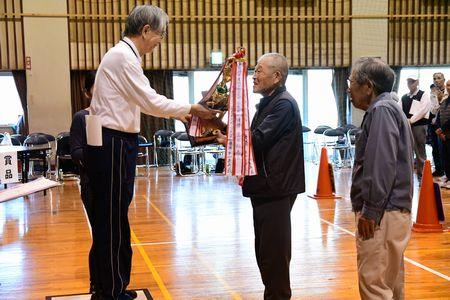 桑山地区代表の男性が優勝トロフィーを受け取っている写真