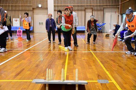 女性が輪投げの台に向かって輪を投げている写真