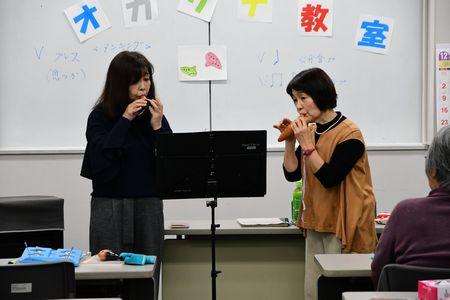 小山 京子さんともう一人の講師の女性が前に立って二人でオカリナを演奏している写真
