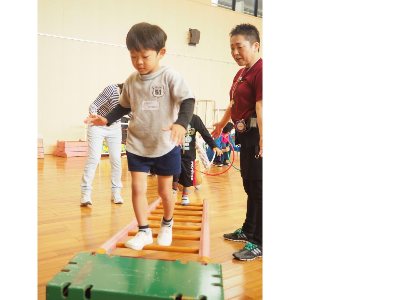 巧技台の梯子を渡る子ども