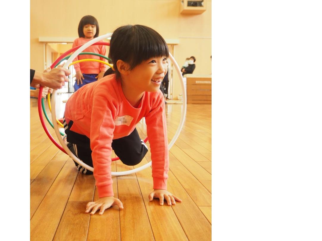 フラフープのトンネルをくぐる子ども