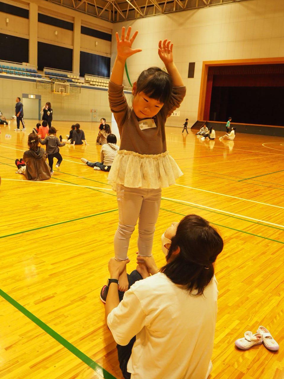お母さんのヒザの上でバランスを取る子ども
