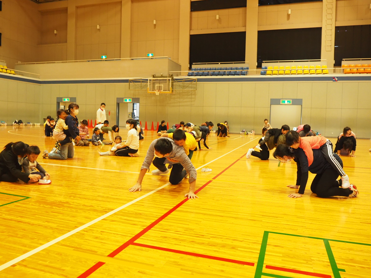 四つん這いの保護者に乗ってしがみつく子どもたち