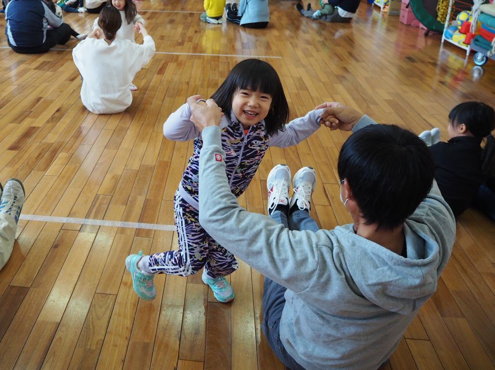 親子体操をする笑顔の子ども