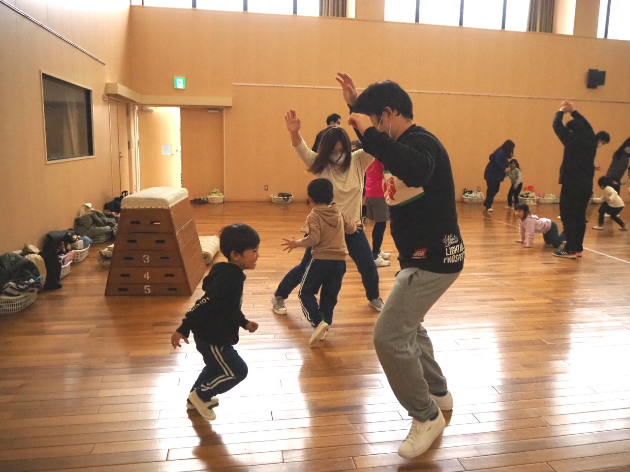 親が両手を挙げたまま追いかけっこ