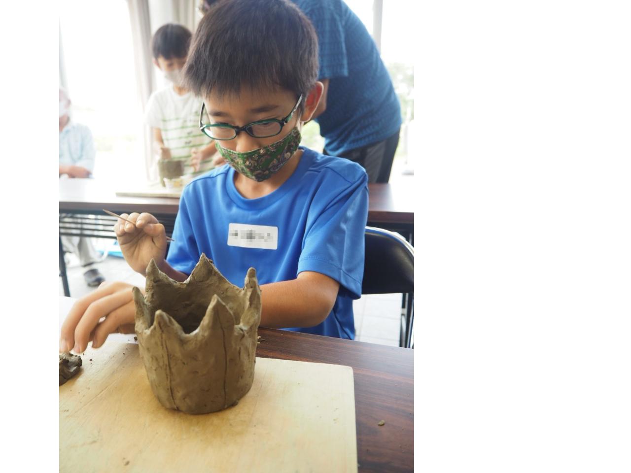 土器の表面に竹串で模様を描く児童