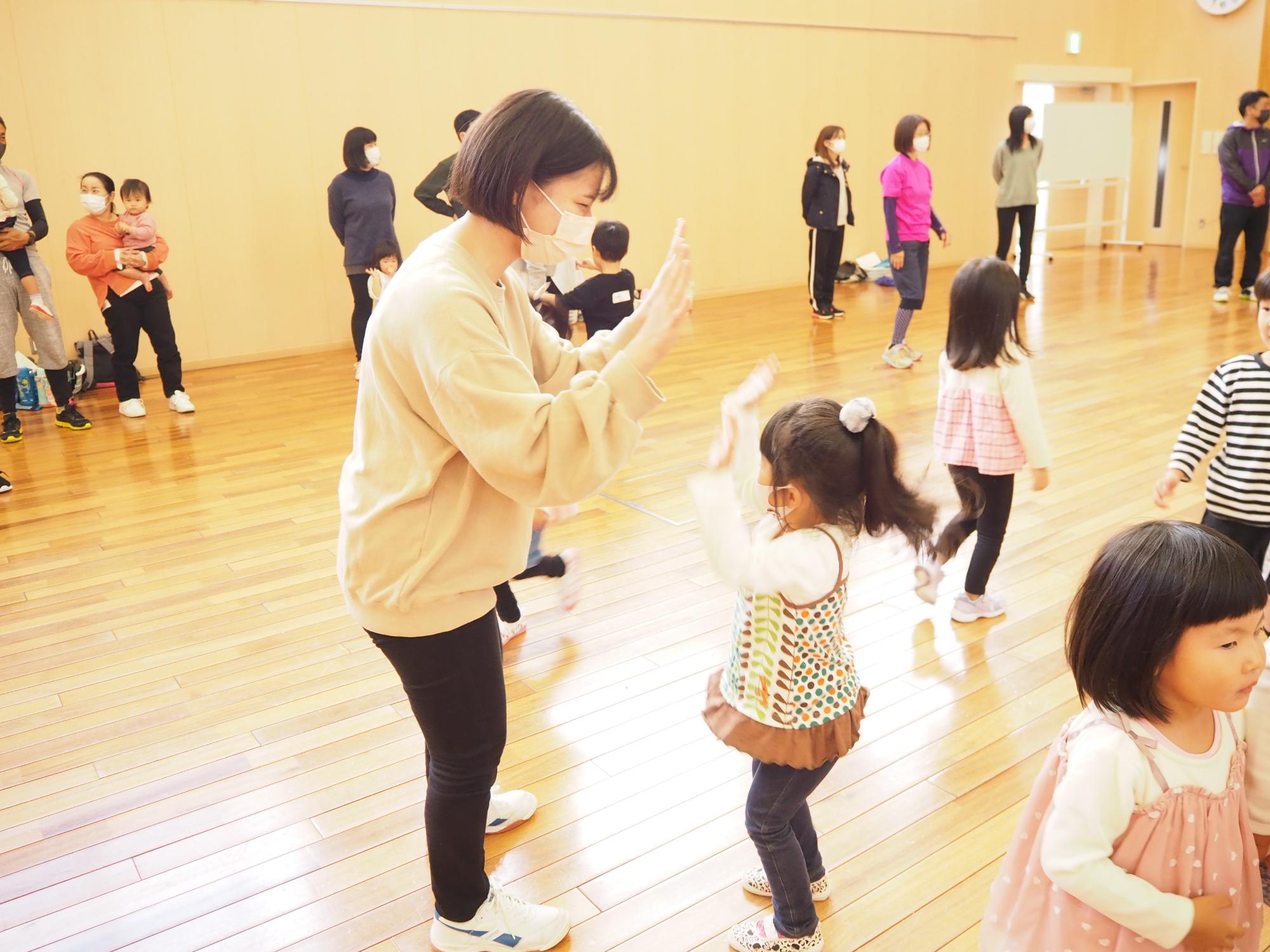 大学生と幼児のハイタッチ