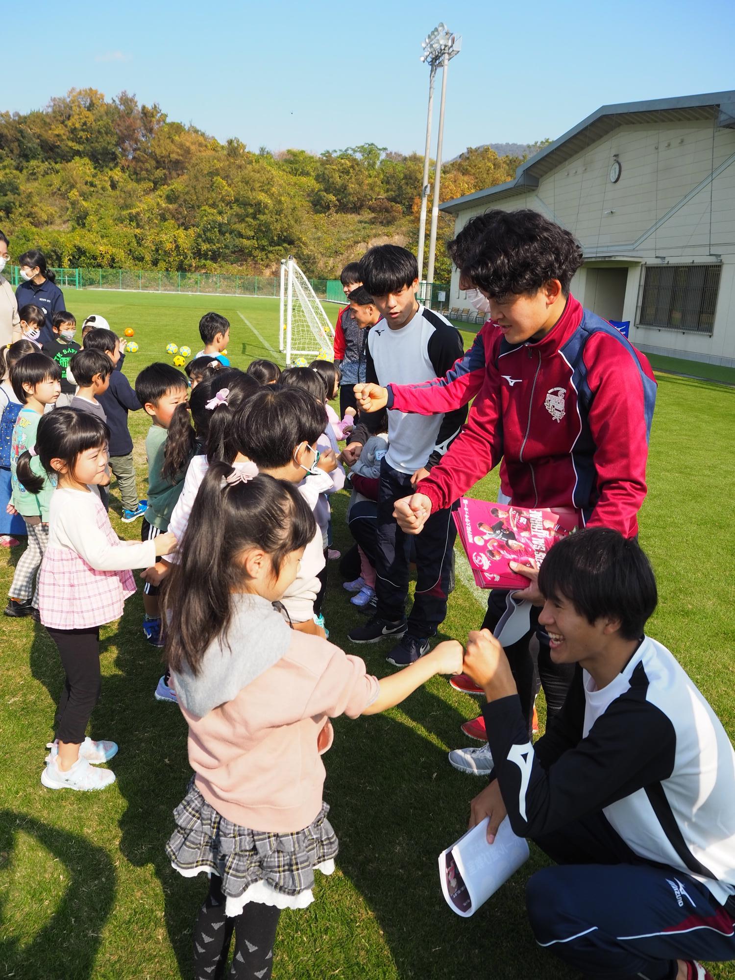 学生と子どもたちがグータッチ