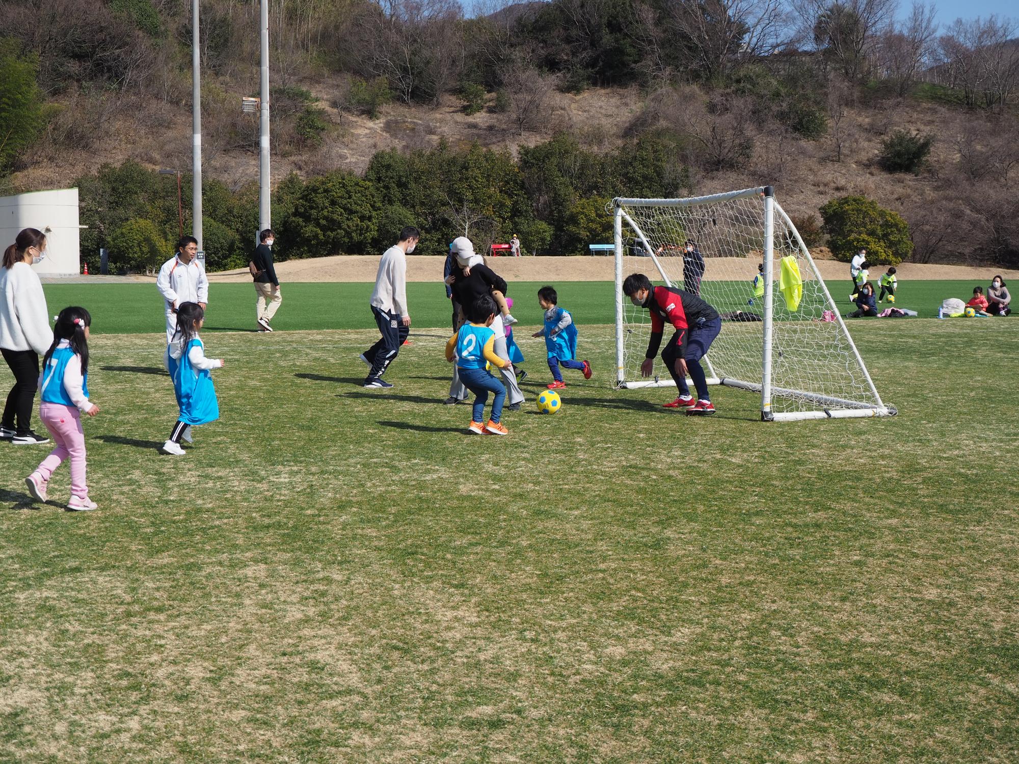 サッカーの試合をする子どもたちとスタッフ
