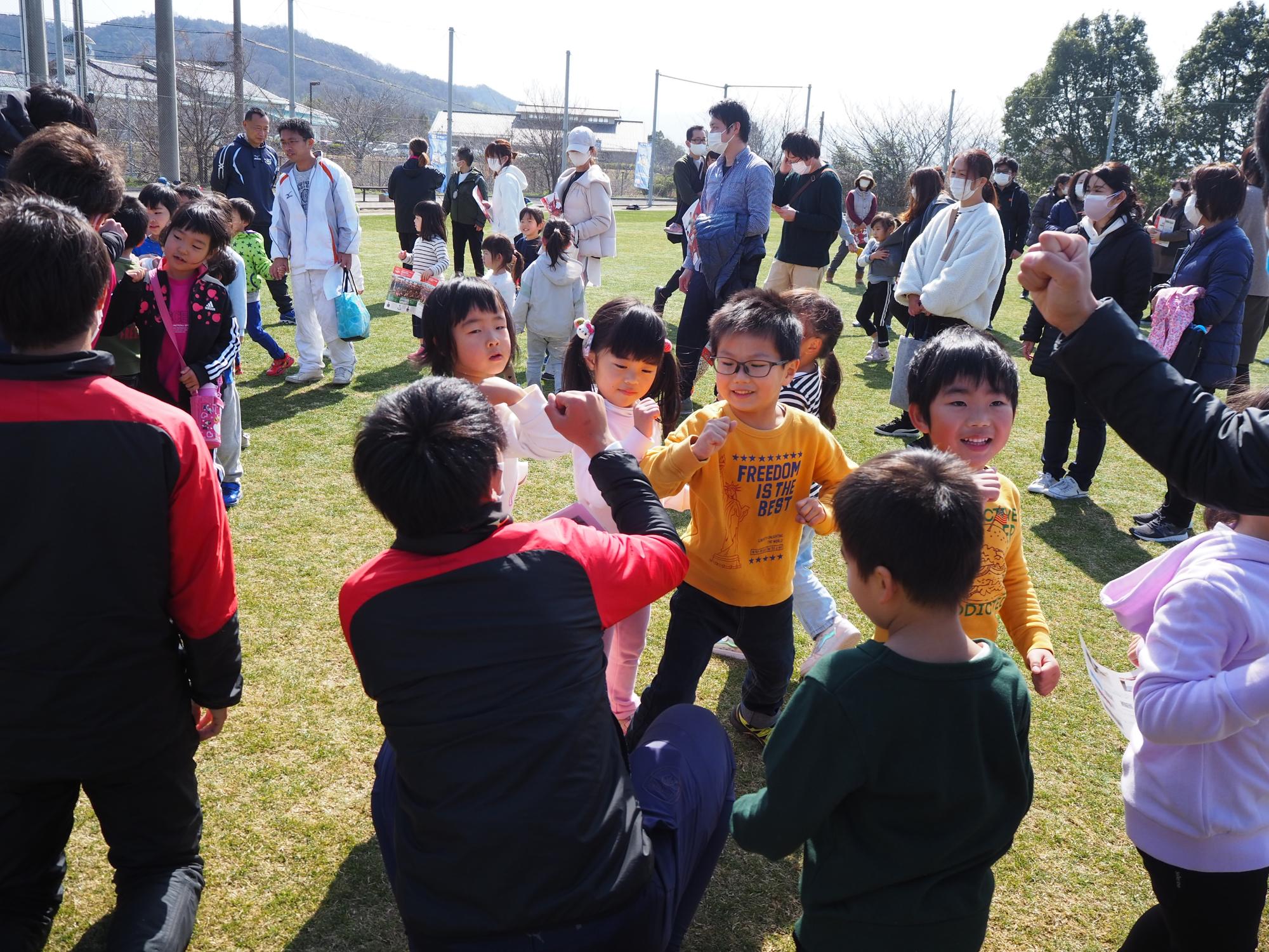スタッフと肘タッチの挨拶をする子どもたち