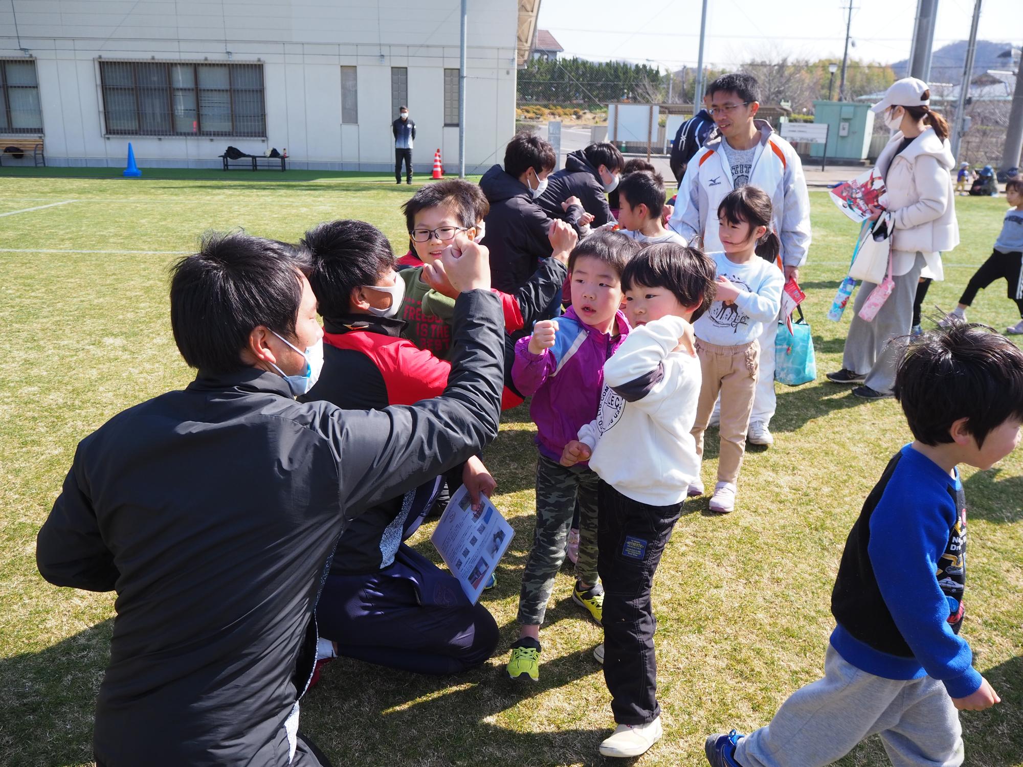 スタッフと肘タッチの挨拶をする子どもたち