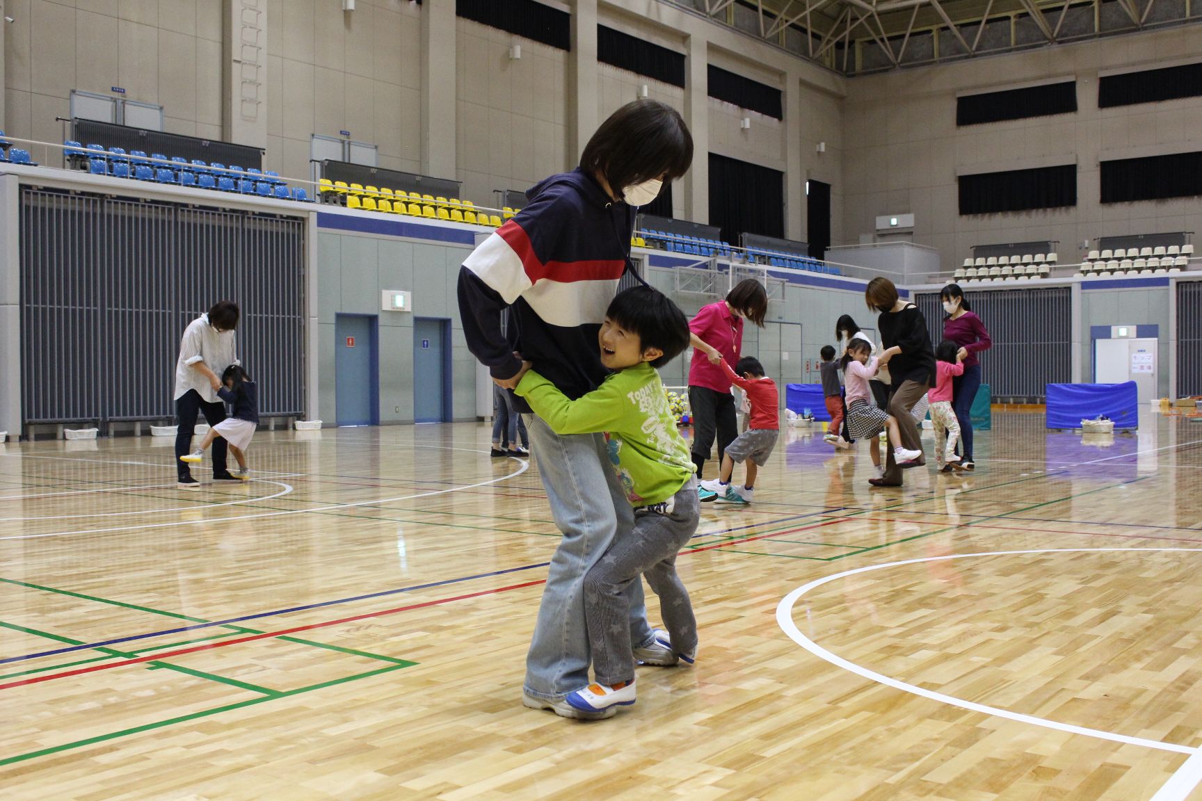 大人の足の甲に乗りしがみつくこども