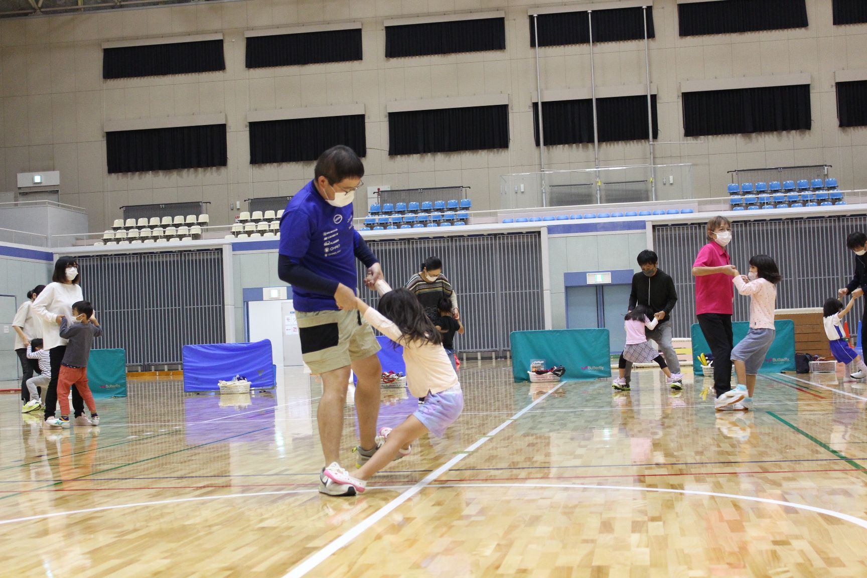 大人の足の甲に乗り、振り回されるこども