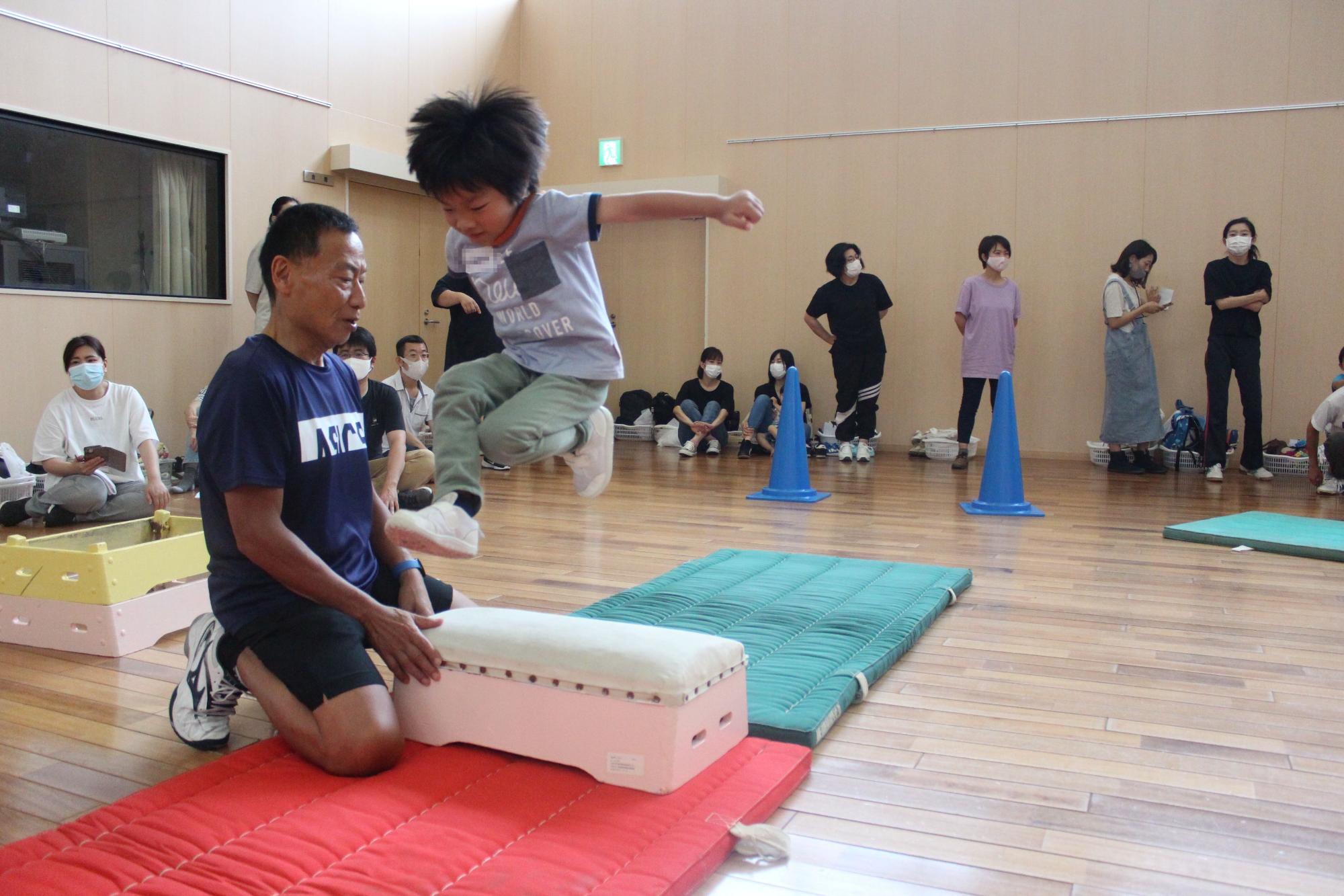 低い跳び箱をジャンプで飛び越える