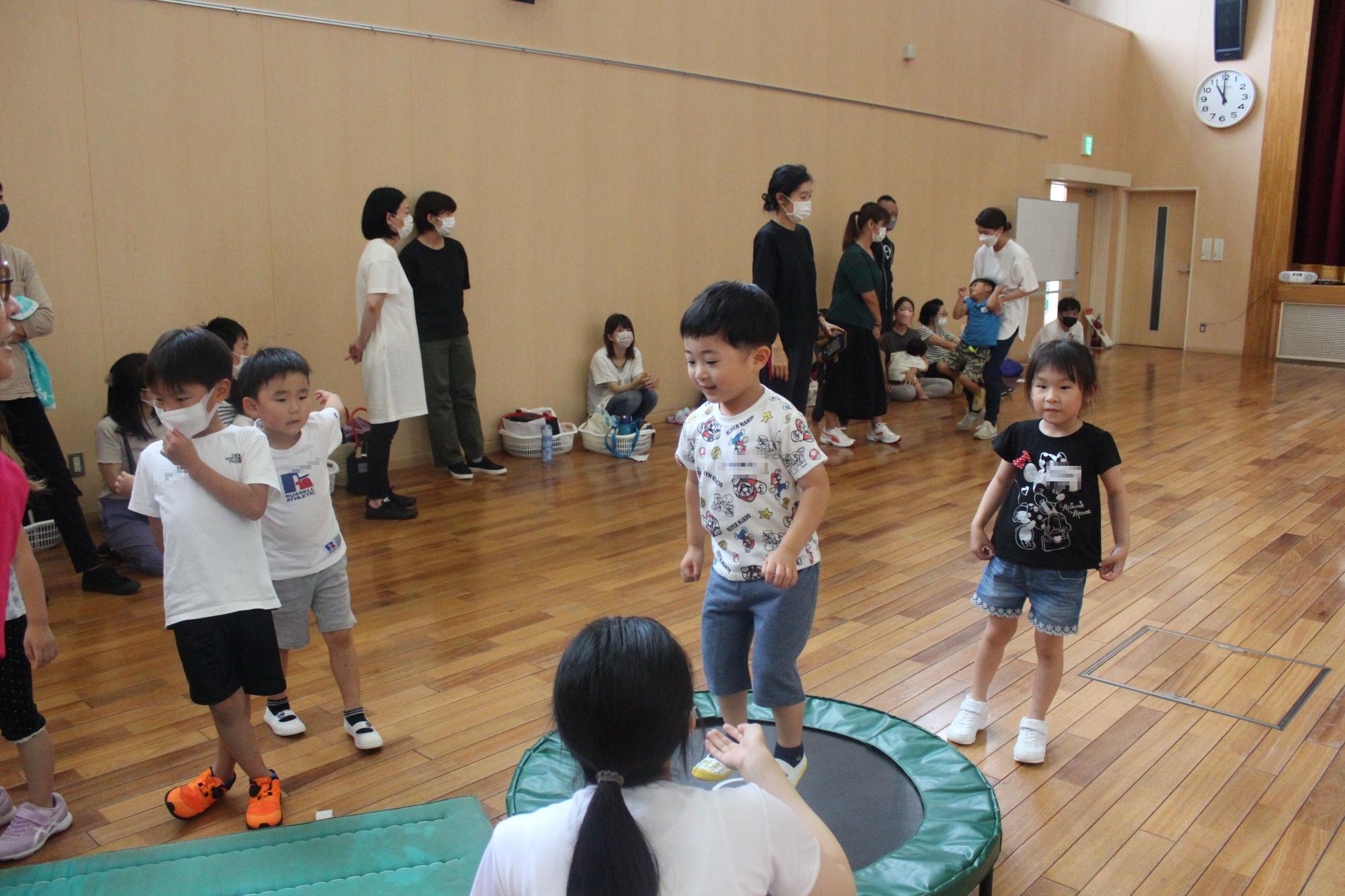 トランポリンをする子どもと見守る学生