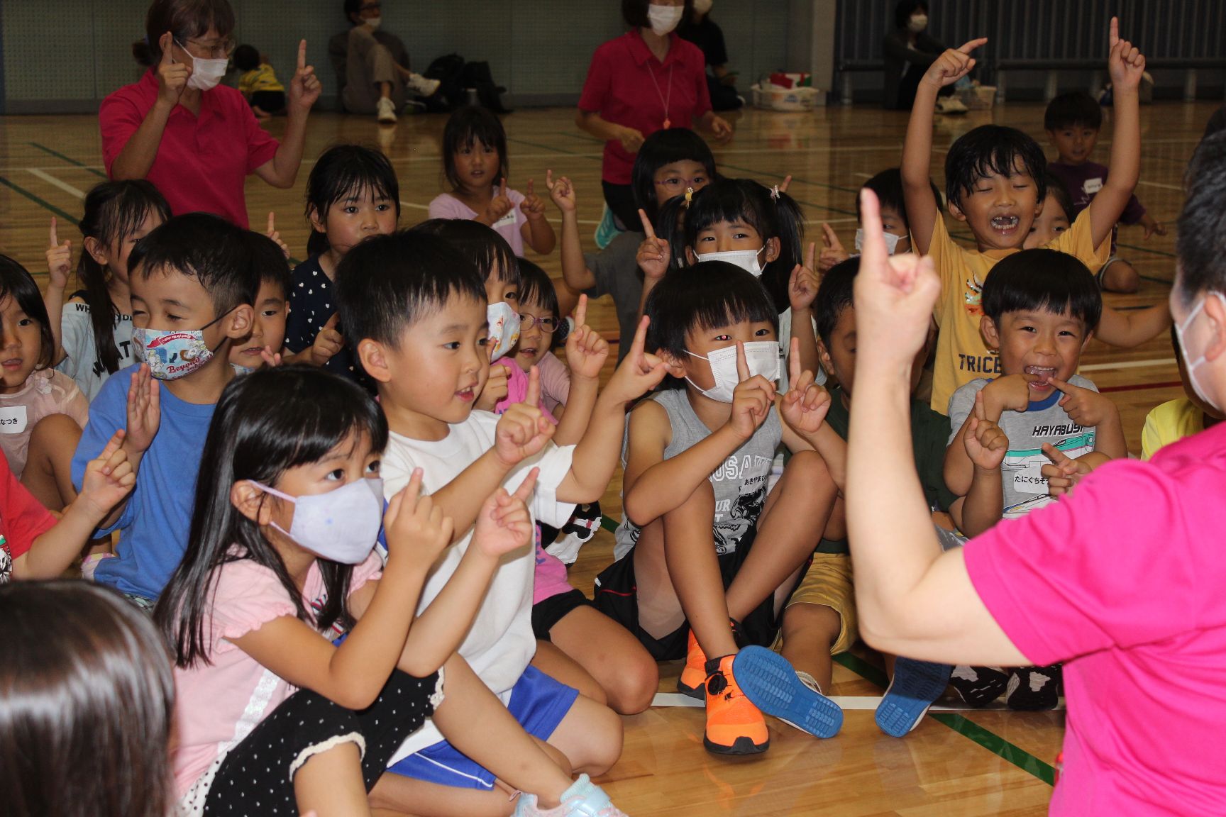笑顔で手遊びをする子どもたち