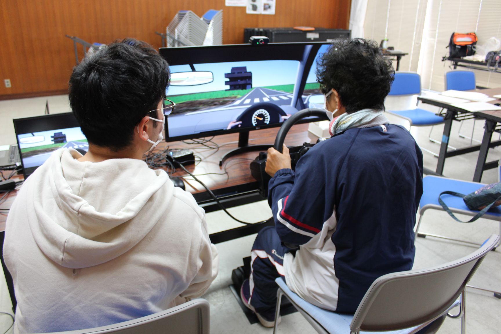 学生に見守られながら走行テストを受ける受講生