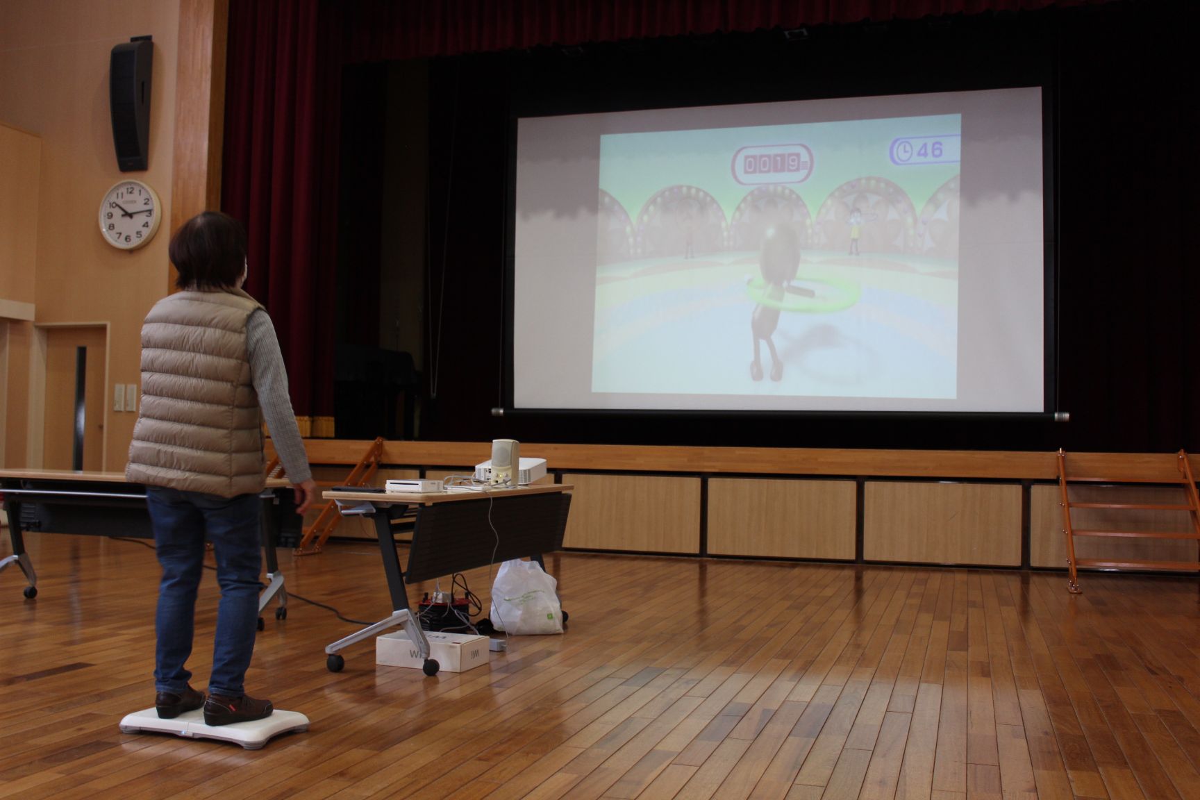 大スクリーンに映し出されるゲーム画面とゲームをする受講生