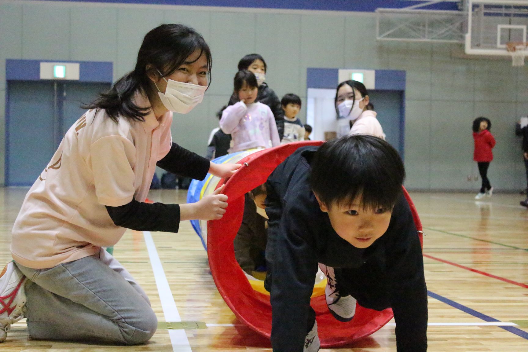 実習生とトンネルくぐりする子ども