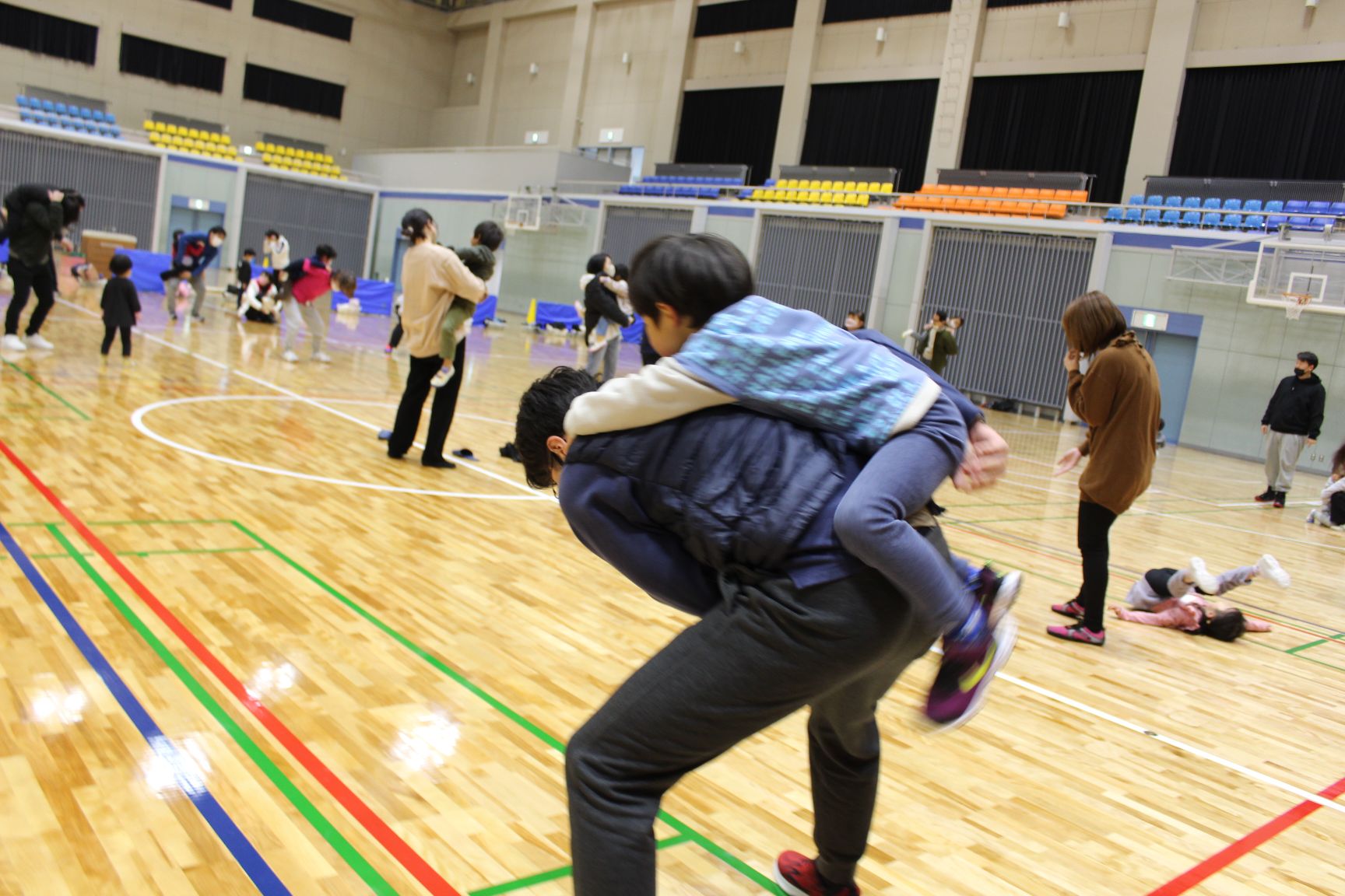 保護者のからだのまわりをよじ登ったまま一周する子ども