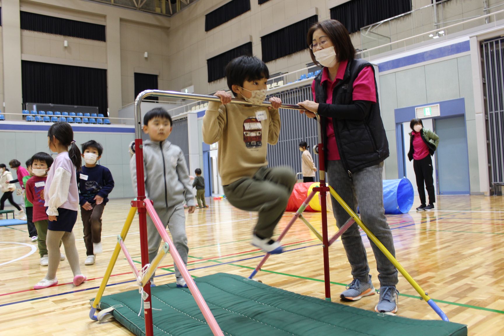 鉄棒で懸垂に挑戦する子ども