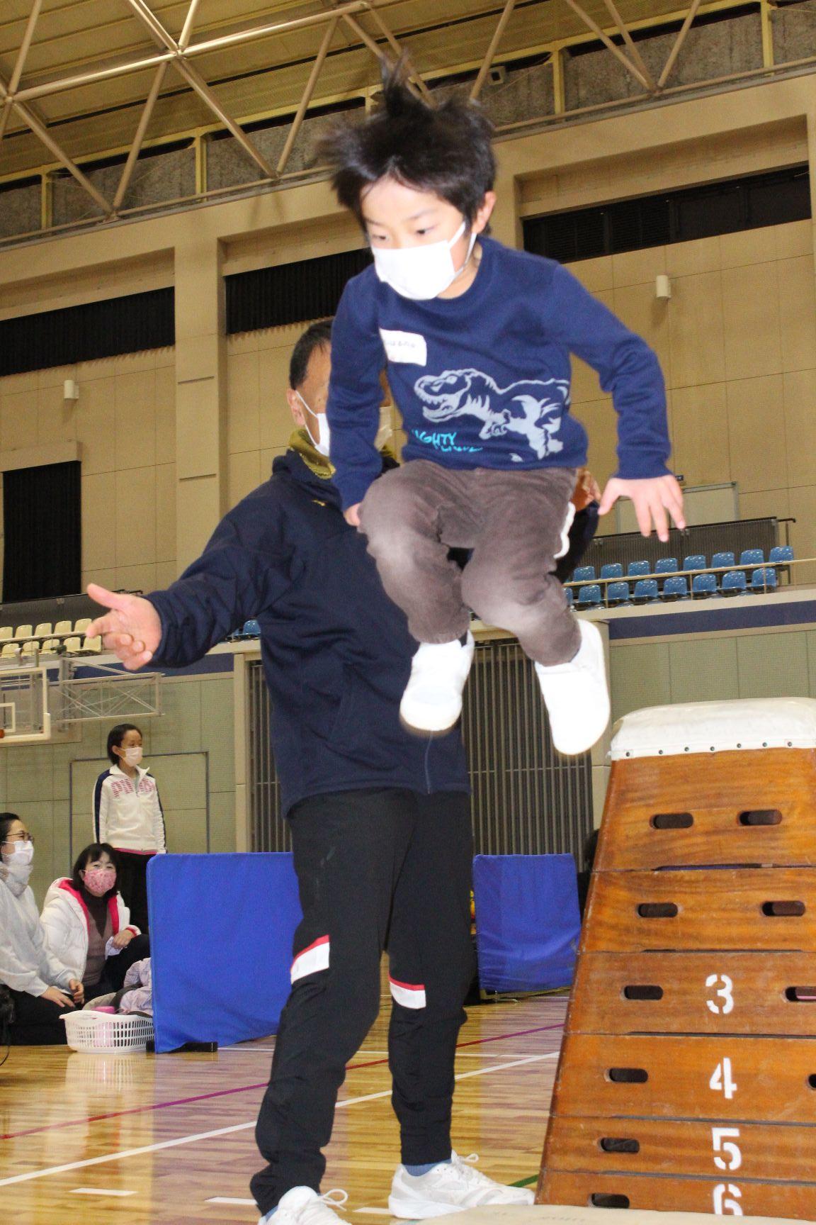 跳び箱から飛び降りる子ども