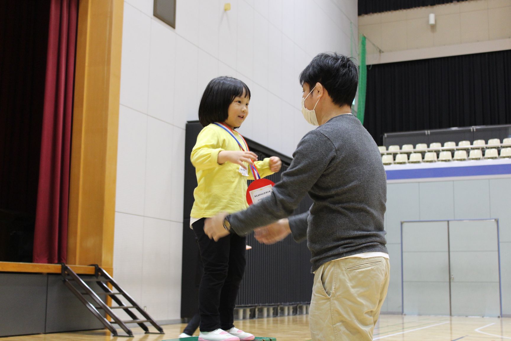 保護者にご褒美メダルをかけてもらう