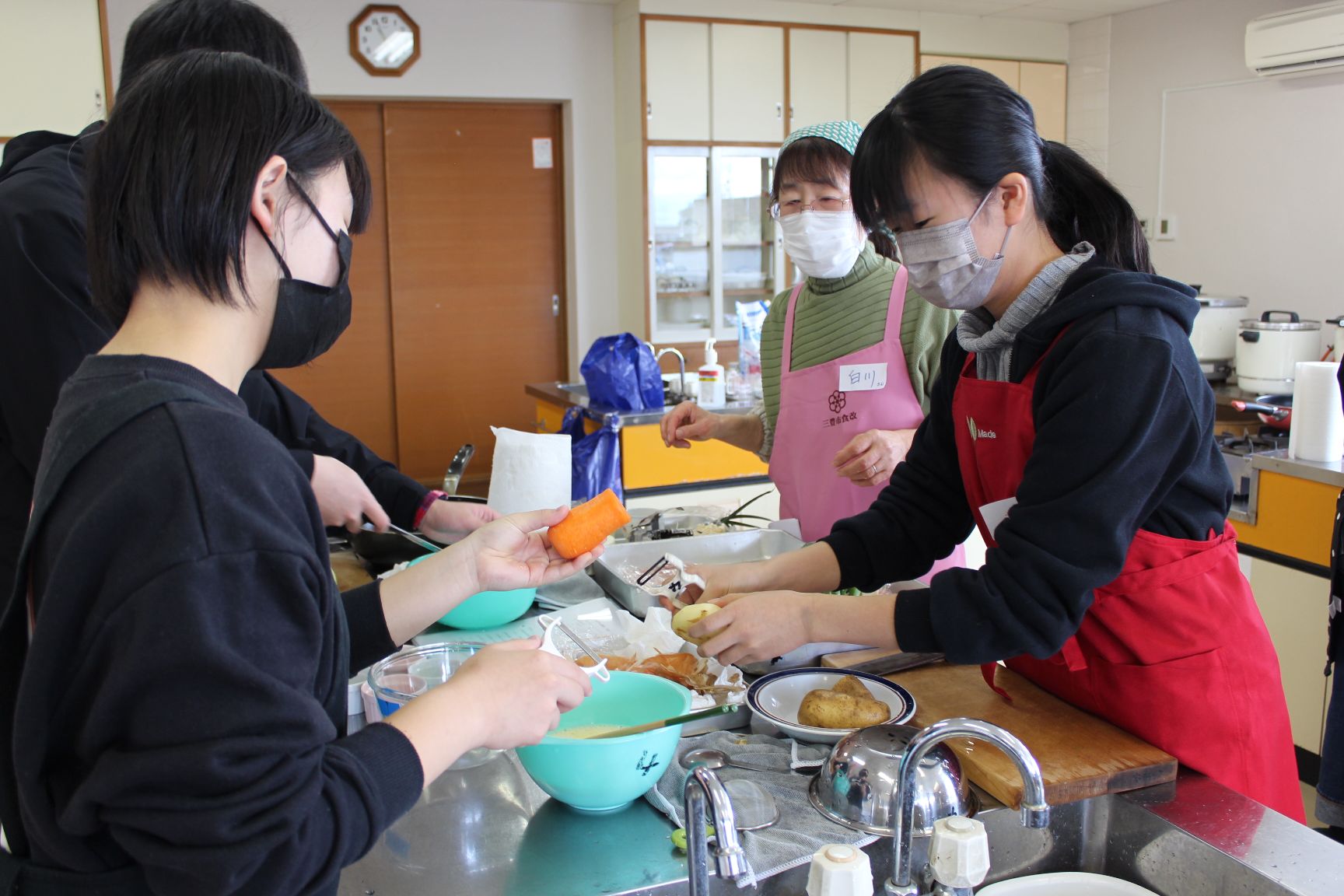 野菜の皮をむく高校生たち