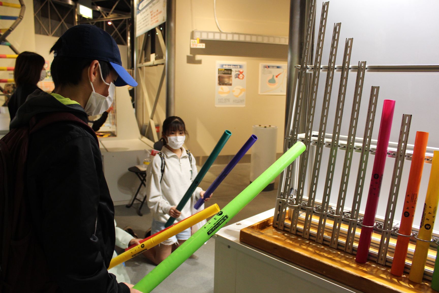 科学博物館の音階になっているポールで遊ぶ小学生