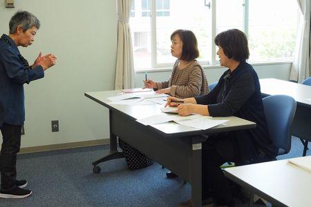 大井 敬子さんが手振りを交えながら、座っている参加者の女性2人にアドバイスをしている写真