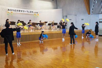 黄色や青のポンポンをもってダンスをしている生徒たちの写真