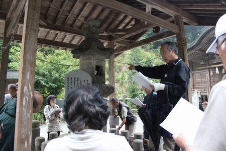 橋詰さんが石造灯篭の前で説明をしている写真