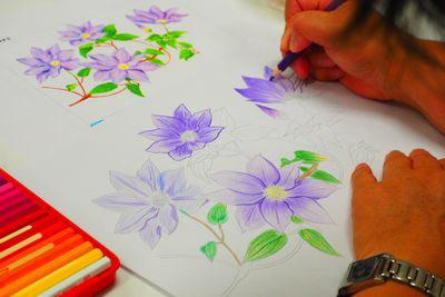 明暗のはっきりした紫色の花を塗っている手元の写真
