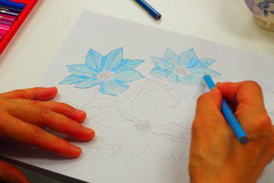 水色を使って花の色を塗っている手元の写真