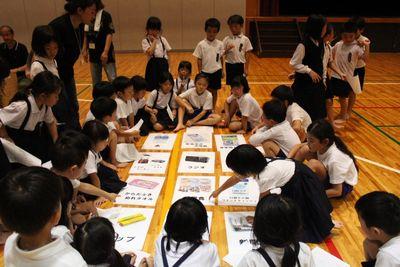 12アイテムのパネルを床に並べて子供達が真剣に話をしている写真