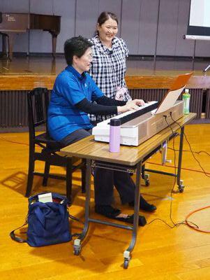 片岡 理子先生がキーボードを演奏している横で大浦 美樹先生が立っている写真