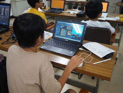 男の子が自分の前にあるパソコンの画面を見ながらマウスを使っている写真