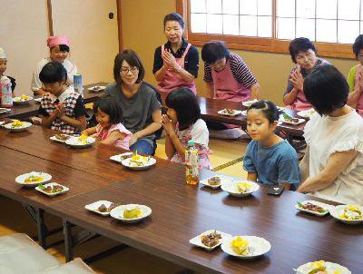 並べられた高瀬茶パンケーキと、水無月を前に、両手を合わせていただきますをしている親子や、関係者、子供たちの写真