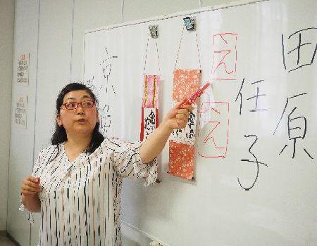 京免 栄美子先生がホワイトボードに書かれた「え」という字をペンで指しながら話をしている写真