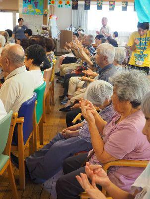 高齢者の方が椅子に座り、みんな手を出して指を使いながら数を数えている写真